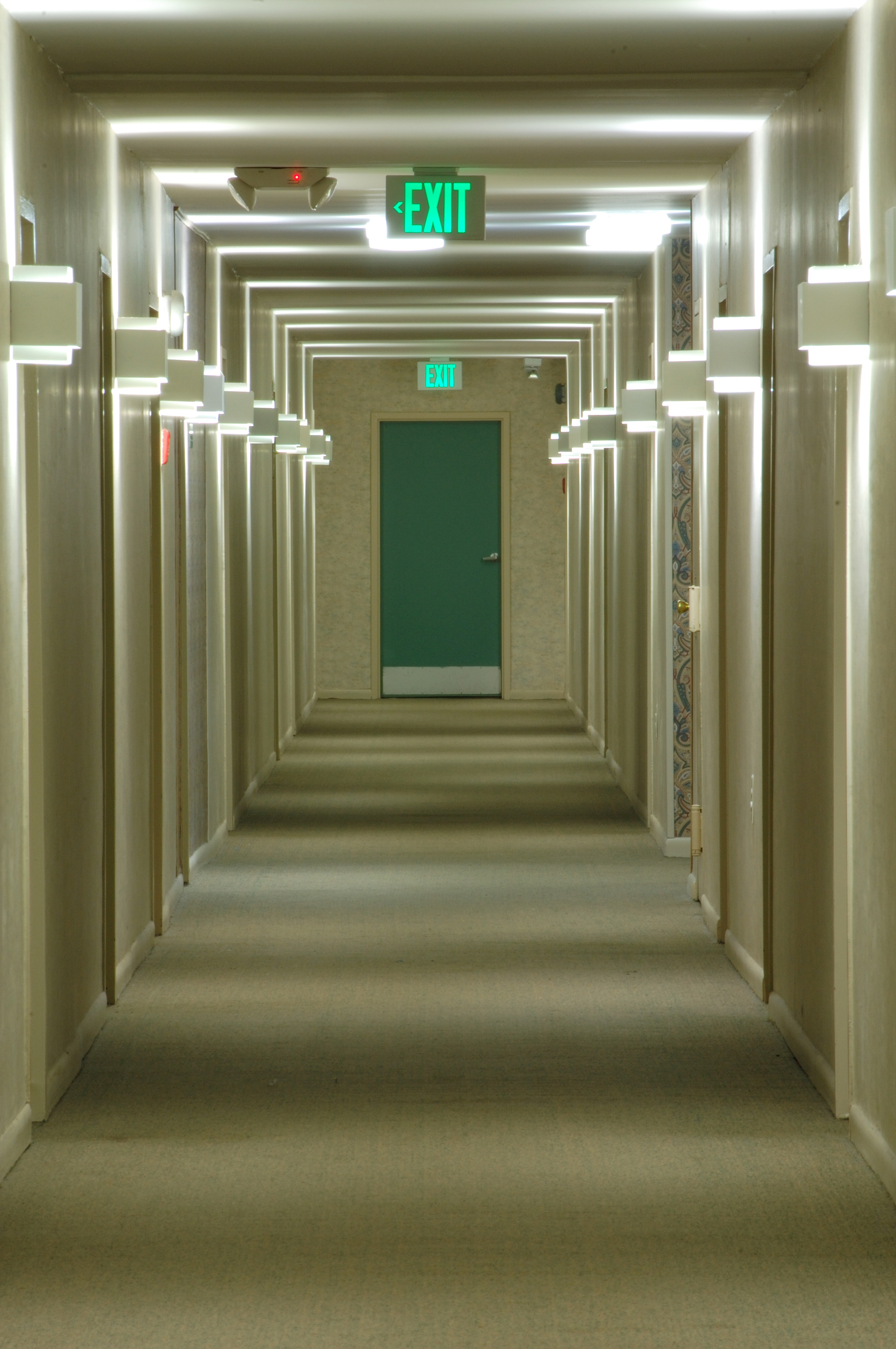 Corridor with a green emergency exit door at the end